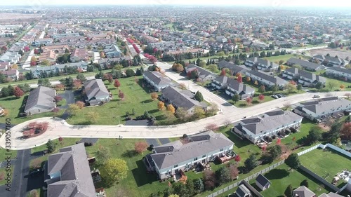 Overhead aerial view of colorful autumn trees residential houses and yards along suburban street - Travel and leisure concept