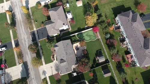 Overhead aerial view of colorful autumn trees residential houses and yards along suburban street - Travel and leisure concept