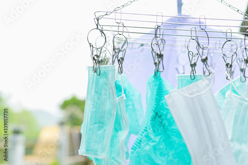 Medical mask hanging on clothesline ,Wash with soap Sterilized by sun Reuse mask for protection diseases and prevention of the spread and epidemic of coronavirus Because the mask is lack not enough