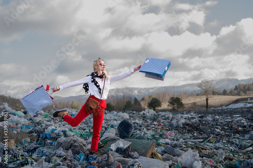 Modern woman on landfill, consumerism versus pollution concept. photo
