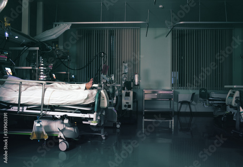 Patient surrounded by advanced life saving equipment in the intensive care unit at night