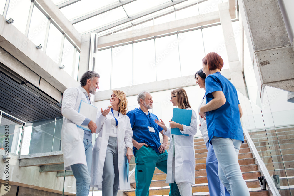 Group of doctors standing on staircase, talking.