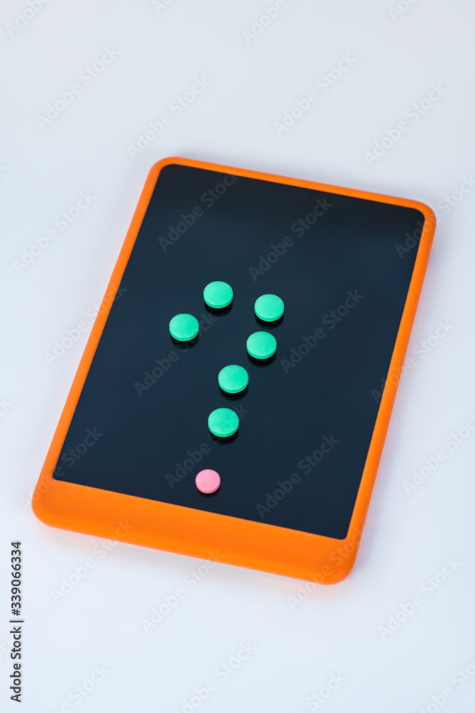Query sign made from colorful pills on a smartphone screen