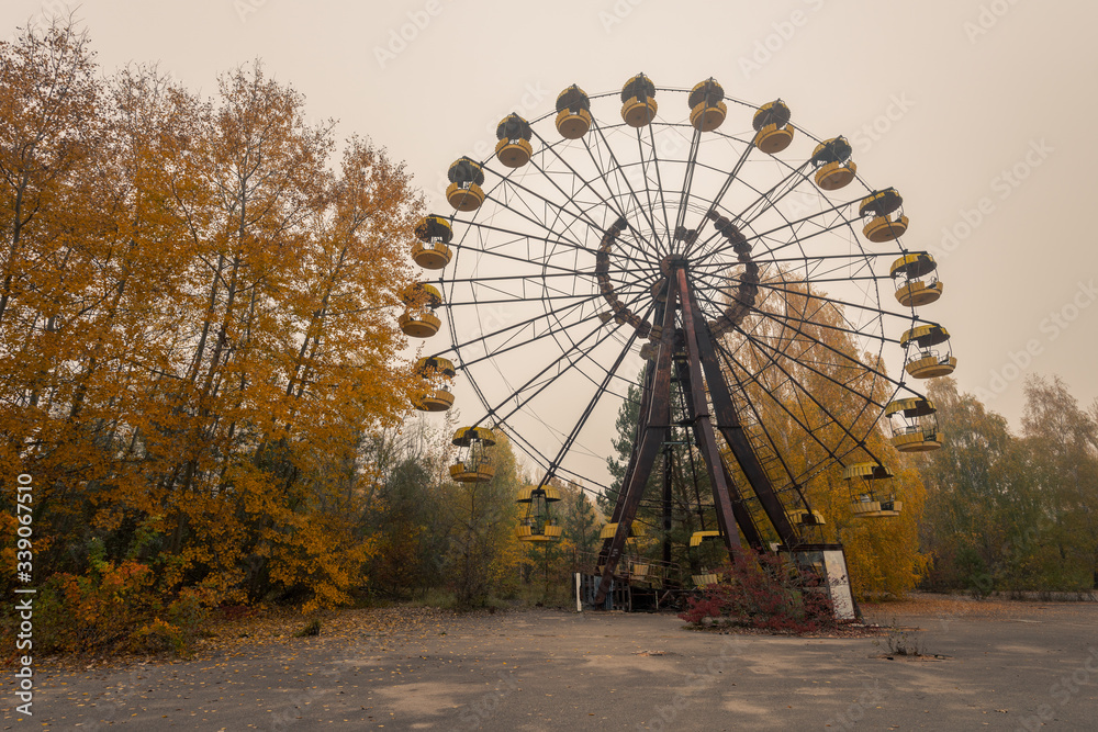 Wide shot of big ferris wheel in abandoned amusement park in Pripyat, Chernobyl Exclusion Zone in autumn