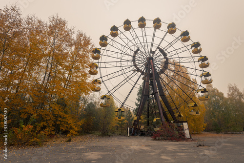Wide shot of big ferris wheel in abandoned amusement park in Pripyat, Chernobyl Exclusion Zone in autumn