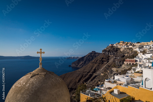 Looking over the top of an old church dome on the edge of the town of Fira on the island of Santorini, Greece