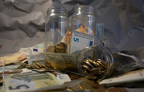 Euro coins and banknotes in a jar.