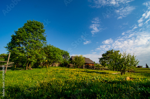 Wooden house farm on meadow with clouds in the sky