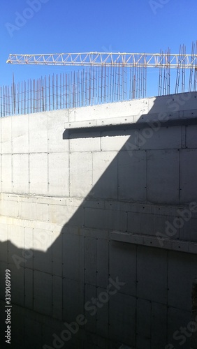 Construction in progress. Concrete wall and the crane