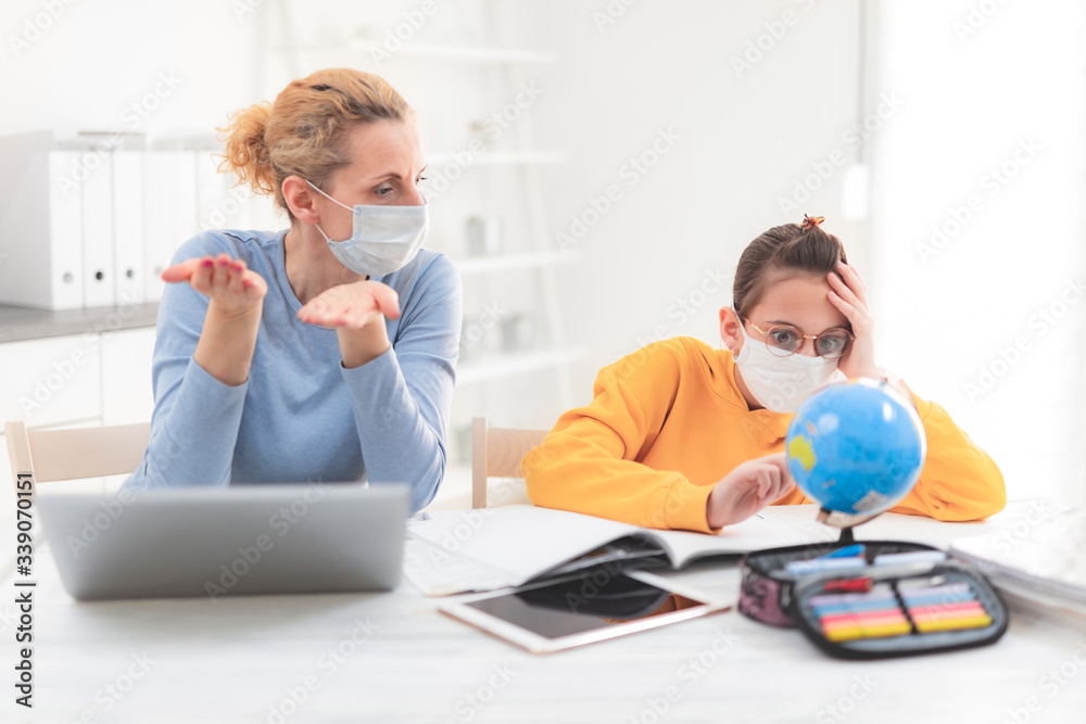 Fototapeta premium Child home studying education, homeschooling, with private tutor / mother with protective mask in the time of viruses, flu and seasonal pandemic, healthy approach in social contact.