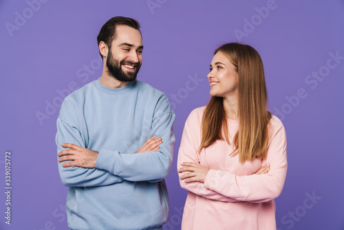 Happy young loving couple isolated over purple background. © Drobot Dean