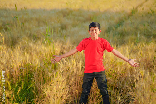 young indian child playing at wheat field, Rural india