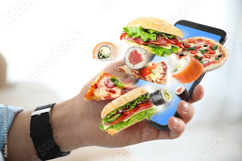 Φωτογραφία Man using smartphone for ordering food online, closeup