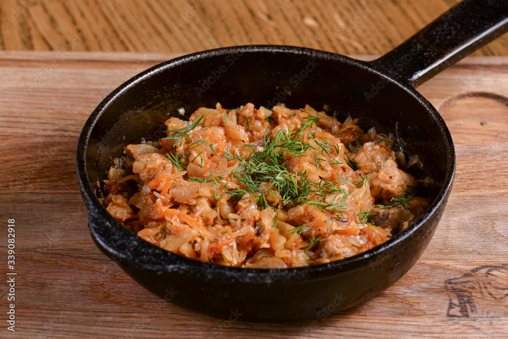 Vegetable and meat stew served in a pan over rustic wooden background table. Ukranian Traditional cuisine.