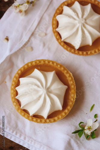 lemon cheesecake pie on wooden background with flower petals