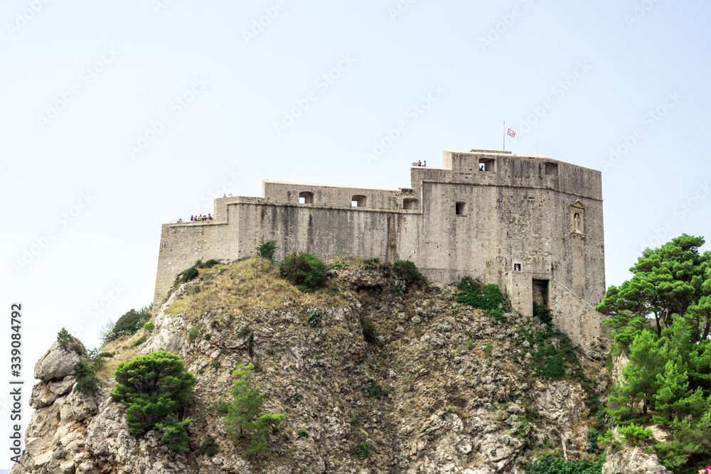 Fototapeta premium Dubrovnik old town city view, old castle view, Ancient fortress view and houses, a castle on the sea bay, hand made walls build with old bricks and stones, Croatia