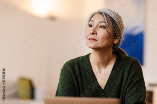 Obraz na plátně Beautiful grey-haired woman using laptop computer indoors.