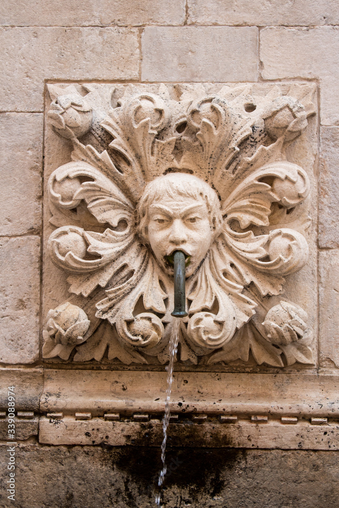 Amazing Onophrian Fountain gargoyle with water spout from the mouth the old town of Dubrovnik Croatia Water flowing down
