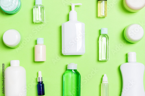 Group of plastic bodycare bottle Flat lay composition with cosmetic products on green background empty space for you design. Set of White Cosmetic containers, top view with copy space