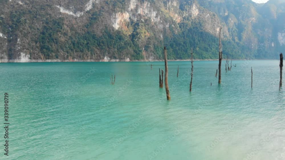Flying Around The Squeaky Clean Water Of Serene Lake In Khao Sok National Park, Surat Thani, Thailand Surrounded By Limestone Cliffs.-  aerial drone shot