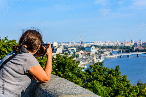 Young woman taking a photo of Kiev cityscape and river Dnieper