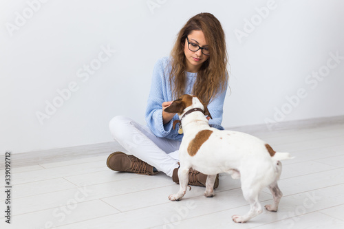 Pets owner concept - Attractive cheerful female in blue sweater playing with her favourite pet. Happy woman with her jack russell terrier