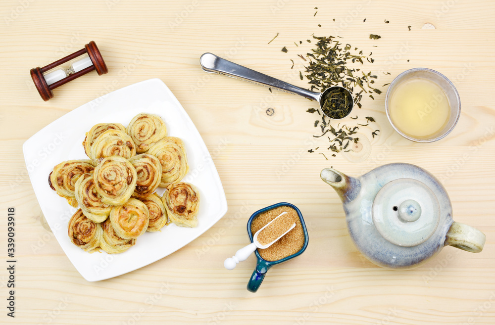 Homemade puff pastry cinnamon rolls served with green tea as breakfast, Czech republic, Europe. Homemade puff pastry cinnamon rolls served with green tea as breakfast, Czech republic, Europe.