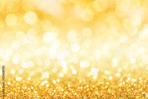 Gold glitter texture. Sparkling gold bright bokeh from blurred diamond dust on black background. Abstract golden bokeh background. Selective focused