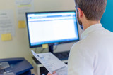 Personnel staff médical au bureau devant écran ordinateur
