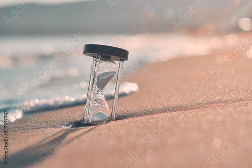 Hourglass at beach coast as time passing concept for business deadline, urgency and running out of time.