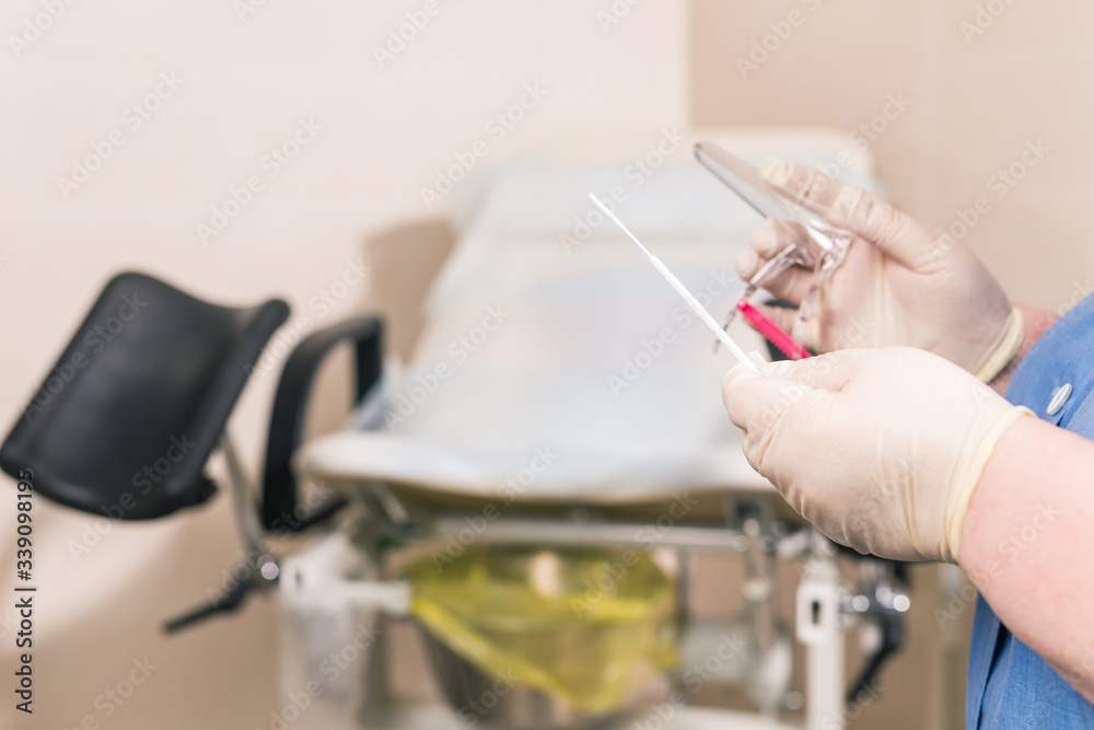 Close-up of doctor hand holds gynecological examination instruments. Gynecologist working in the obstetrics and gynecology department. Medical concept.