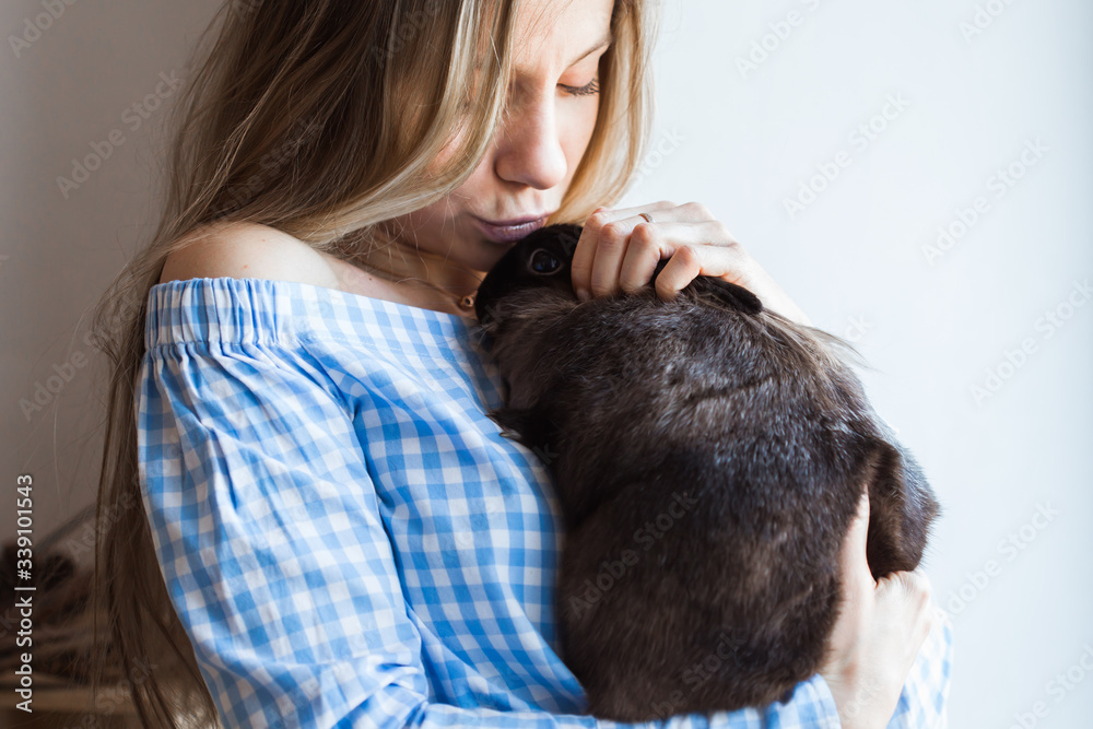 Pet and Easter concept - Happy girl hugging brown rabbit at home. Pet and Easter concept - Happy girl hugging brown rabbit at home.