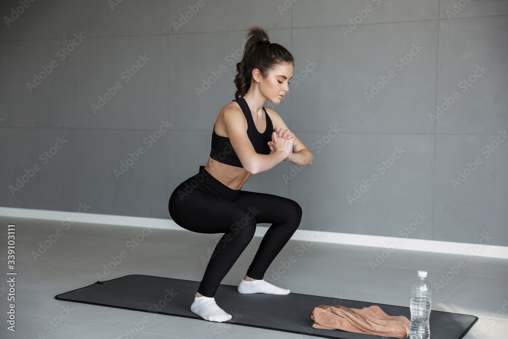 Fototapeta premium Photo of concentrated beautiful woman doing exercise while working out