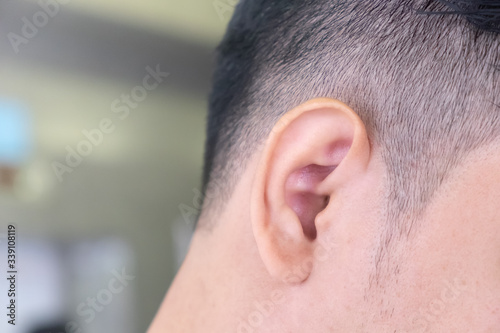 Close up of the right ear of a man and the place on the left side for placing letters.