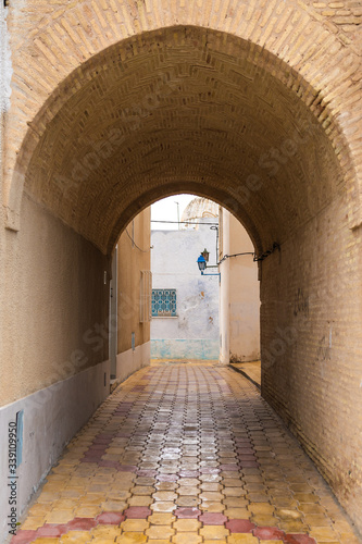 Vertical color photography of narrow streets of old city in Tunisia country. Walls of old buildings.