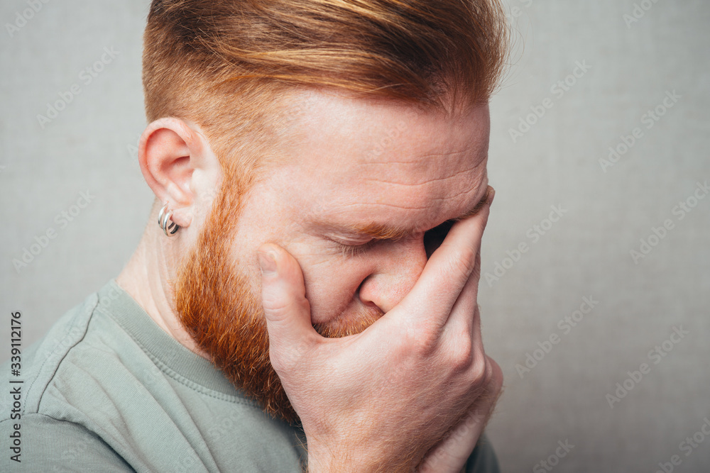 Fototapeta premium portrait of a Young red bearded Man feel bad, sad