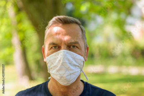 Head shot of a man wearing a surgical face mask