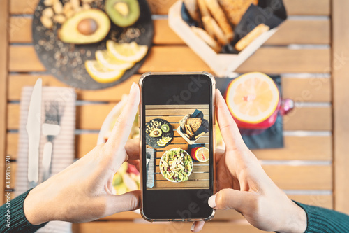 Top view female hands taking photo with mobile smartphone on health lunch food - Young girl having fun with new technology apps for social media - People healthy lifestyle and tech addicted concept