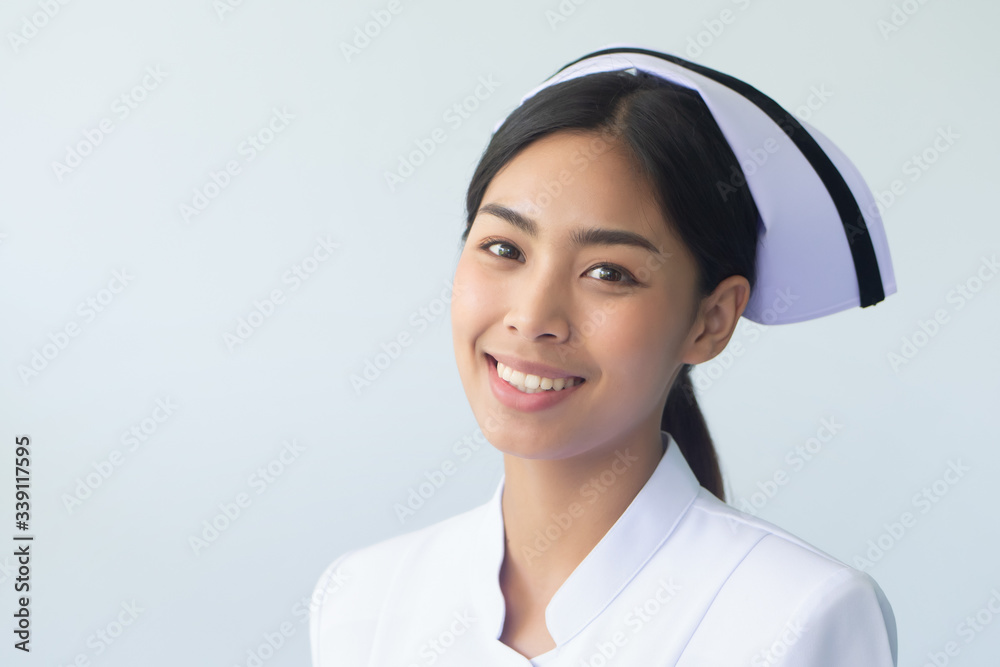 portrait of smiling asian woman nurse isolated; studio shot of confident friendly successful professional female nurse or medical worker portrait of smiling asian woman nurse isolated; studio shot of confident friendly successful professional female nurse or medical worker