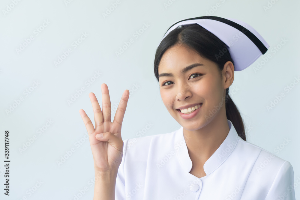 portrait of happy smiling asian woman nurse isolated pointing 4 fingers to blank space; confident and professional female nurse or medical worker pointing four finger up, four points or forth point portrait of happy smiling asian woman nurse isolated pointing 4 fingers to blank space; confident and professional female nurse or medical worker pointing four finger up, four points or forth point