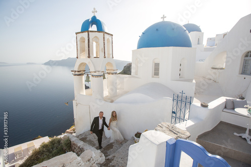 Wedding couple up the stairs of the streets of Santorini.