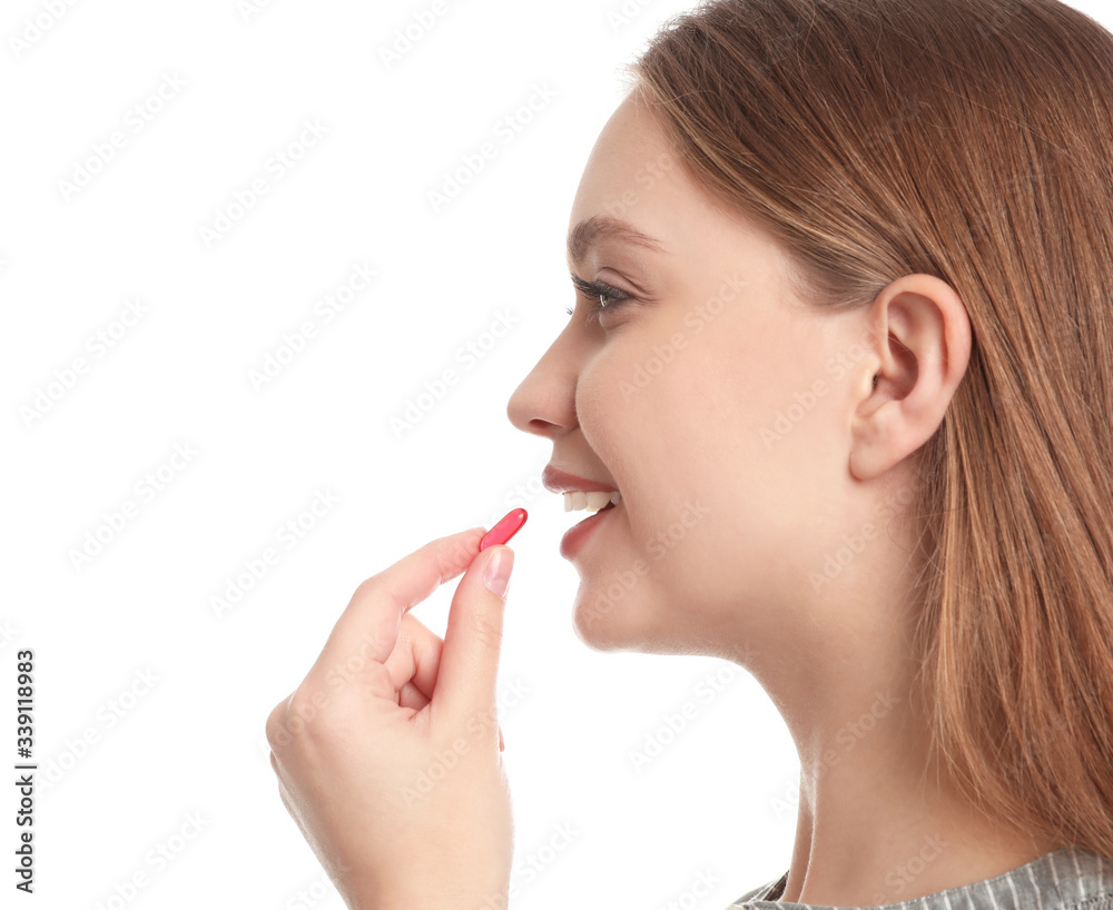 Young woman taking vitamin capsule on white background Young woman taking vitamin capsule on white background