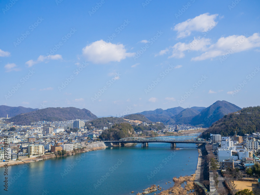 High angle view of the Inuyama Bridge crossing the Kiso River. On a clear day, you can see mountains and skies from Inuyama Castle of Japan.
