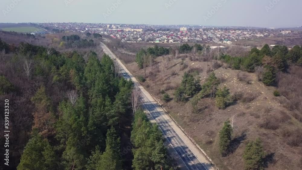 AERIAL 4K: Flight Over Road Running Through Forest. DRONE View at misty hills with country road. Cinematic shot. Early sprimg. AERIAL 4K: Flight Over Road Running Through Forest. DRONE View at misty hills with country road. Cinematic shot. Early sprimg.