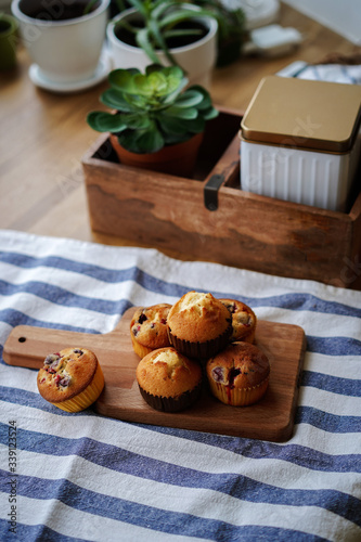 Muffins with cranberries and chocolate are beautifully laid out on the cutting Board, around the atmosphere of home and comfort, beautiful interior, natural wood, a Cup of tea