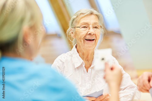 Glückliche Seniorin hat Spaß beim Kartenspiel