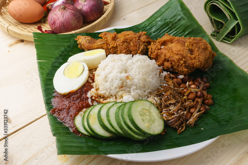 Nasi Lemak-Malaysian cuisine. A fragrant rice dish cooked in coconut milk and pandan leaf commonly found in Malaysia. Served with sambal, anchovies, peanut and cucumber.