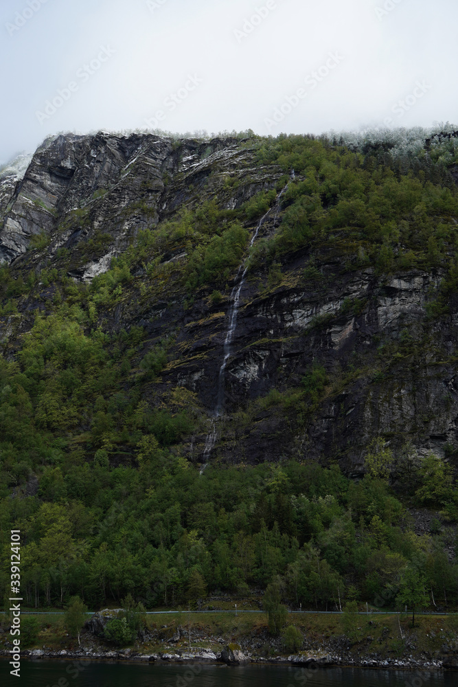 Small waterfall in the forest, between the mountains in Norway.