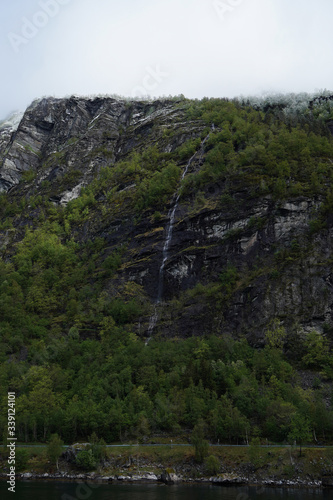 Small waterfall in the forest, between the mountains in Norway.