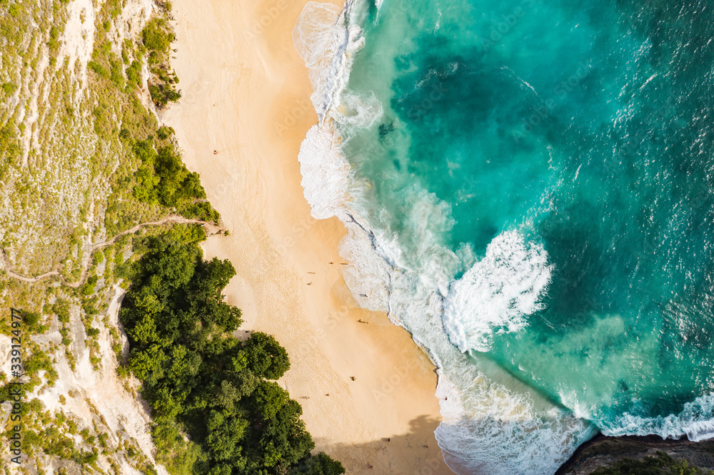 Overhead view of sandy beach and sea with cliff Overhead view of sandy beach and sea with cliff